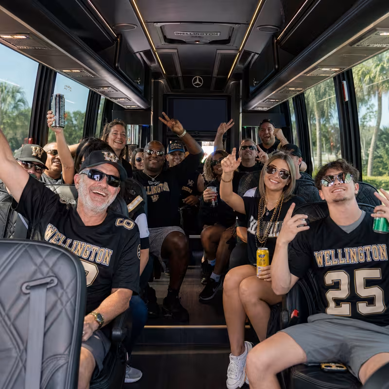 Group boarding a white charter bus for Sporting Event Transportation transportation in Wellington